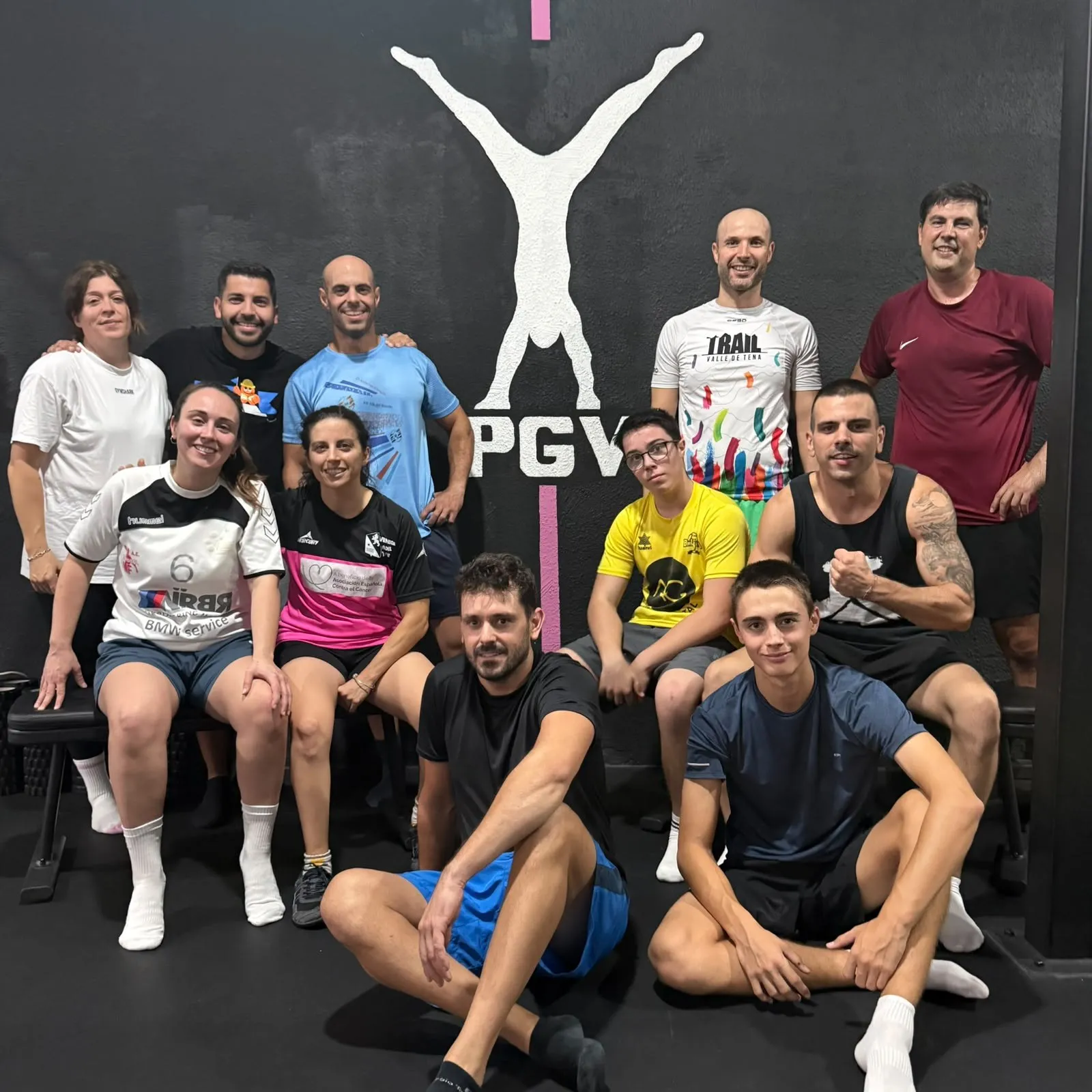 Grupo de alumnos del Team PGV posando tras un entrenamiento frente al logo del centro